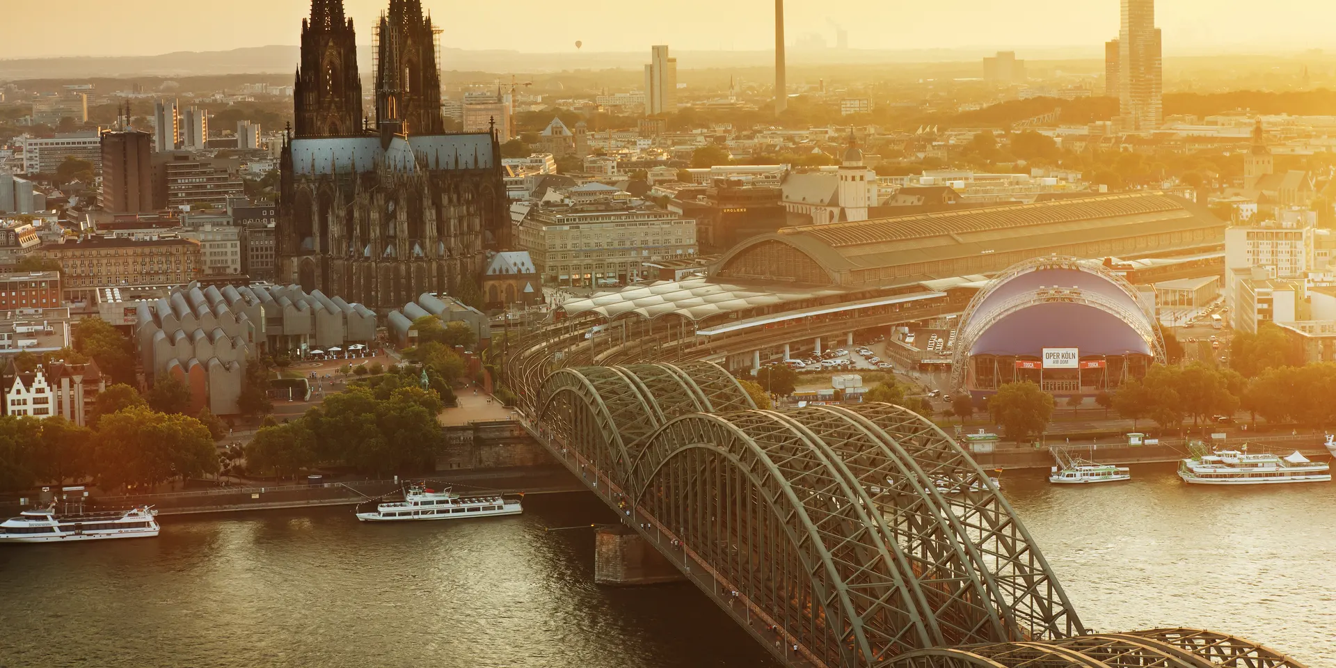 Blick über den Rhein auf Hohenzollernbrücke und Kölner Dom im Abendlicht